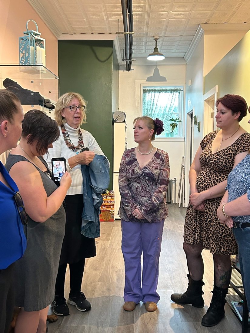 Willow and visitors chatting together inside the studio at the opening.
