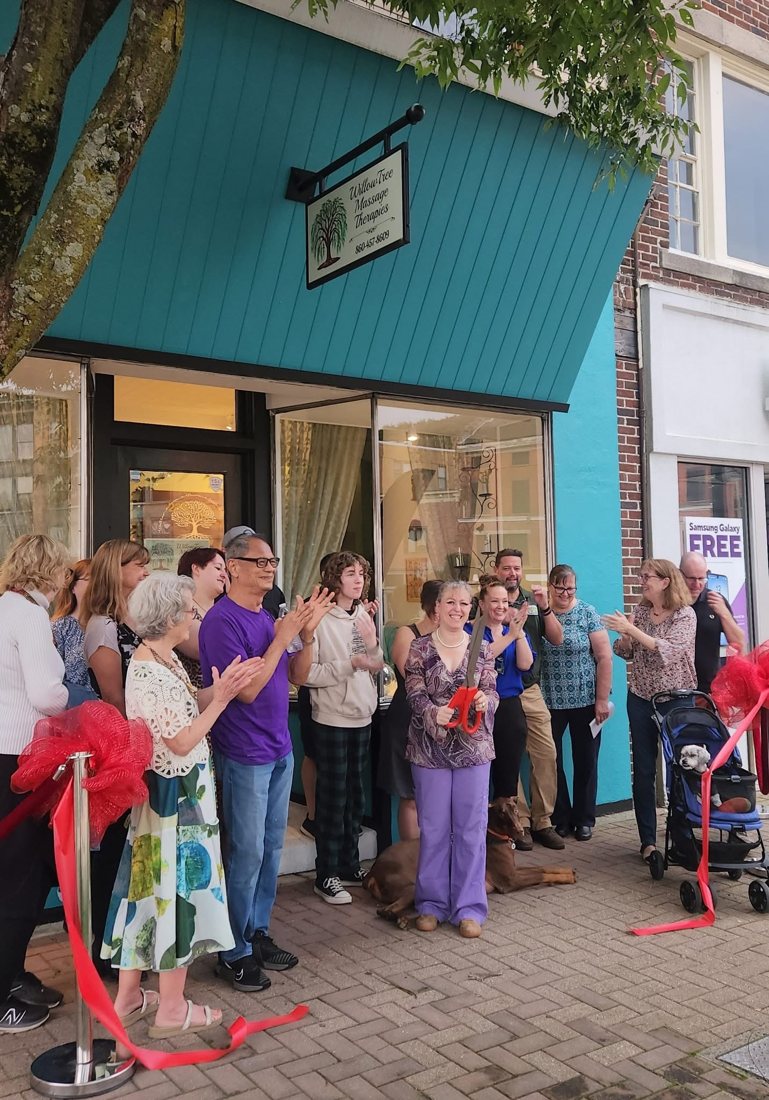 Willow celebrates the ribbon cutting outside the turquoise Willow Tree storefront.